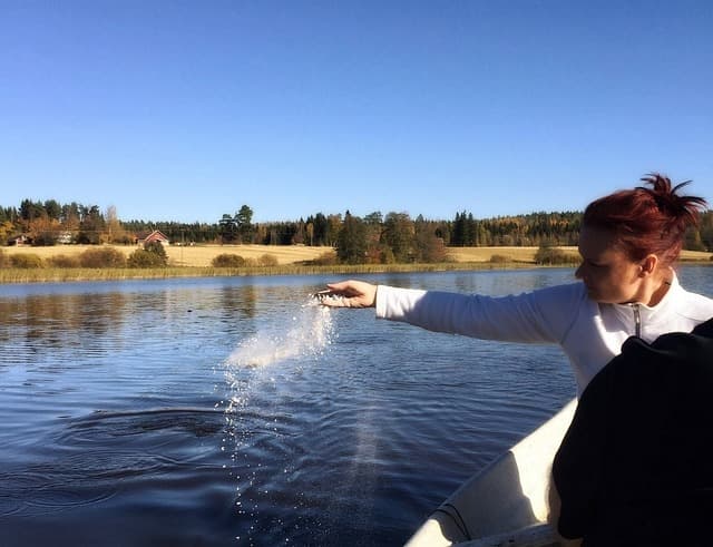 People scattering ashes in a lake